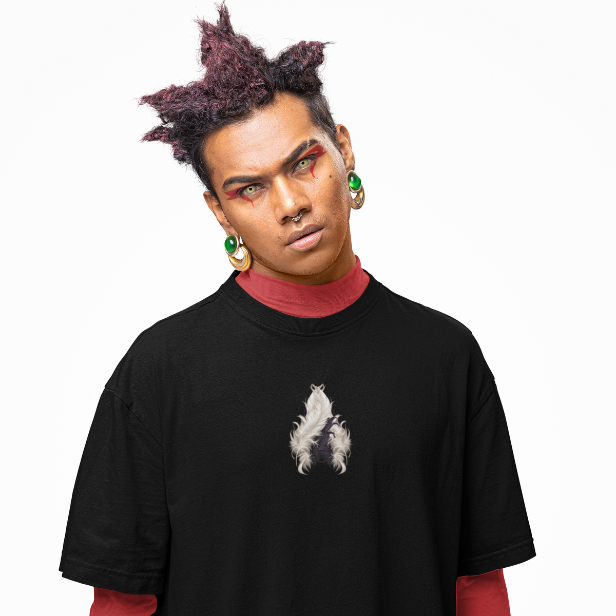 A model wearing a black oversized t-shirt with a small white wolf graphic on the chest, layered over a red long-sleeve shirt and red pants, against a plain white background.